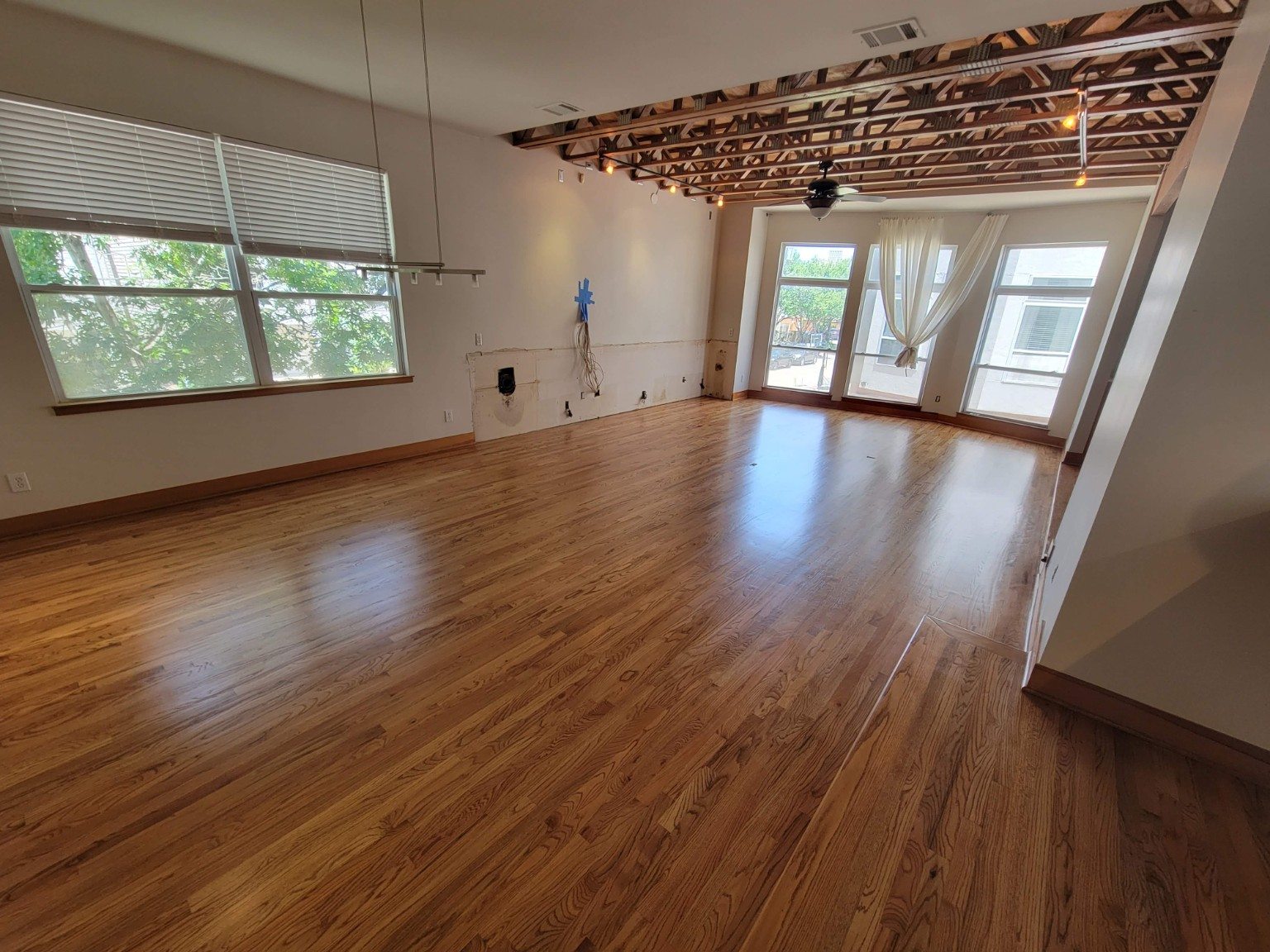 Warm wood flooring across a wide living space