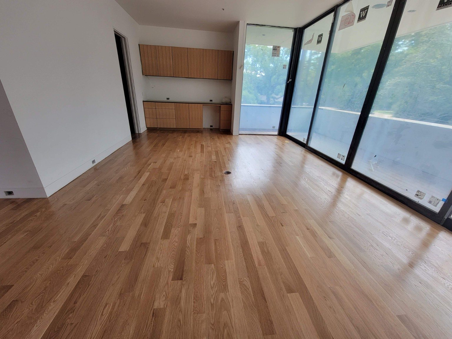 Light wood floor in a modern room with full-height windows